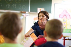 Die Klassenlehrerin reicht dem Vorsitzenden den heutigen Ablauf.